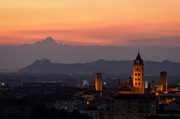 Alba at sunset showing its historic towers against the Monviso mountains